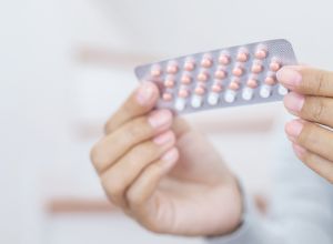 femme qui tient une plaquette de pilule entre les mains