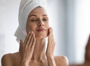 femme qui applique une crème sur son visage