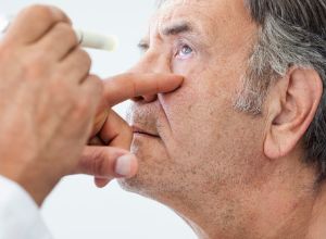 monsieur à qui l'on met des gouttes dans les yeux