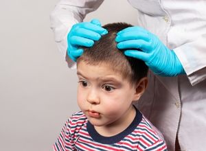 Médecin qui regarde les cheveux d'un petit garçon