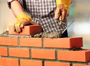 un maçon en train de construire une maison