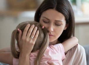 Une mère tient son enfant dans ses bras.