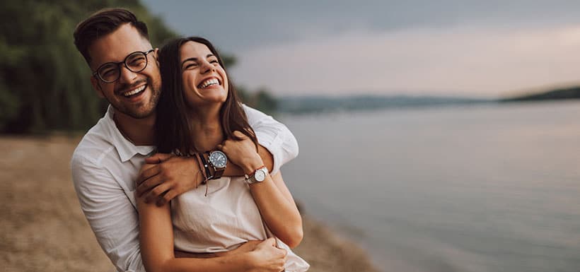 Un homme et une femme enlacés et souriants