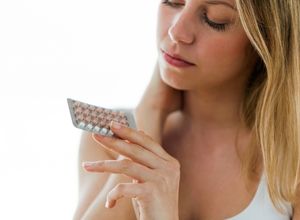 Femme regardant sa plaquette de pilule Migraine cataméniale