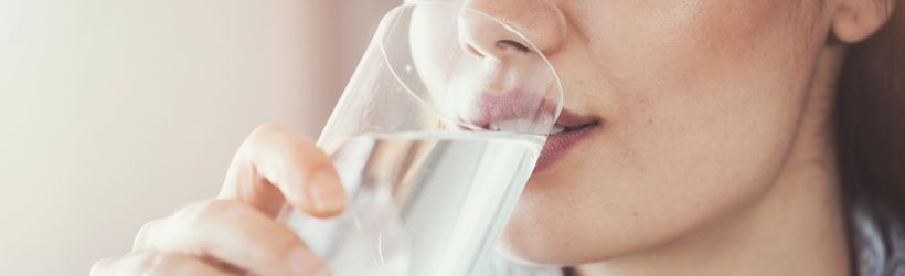 Femme potomanie buvant un grand verre d'eau