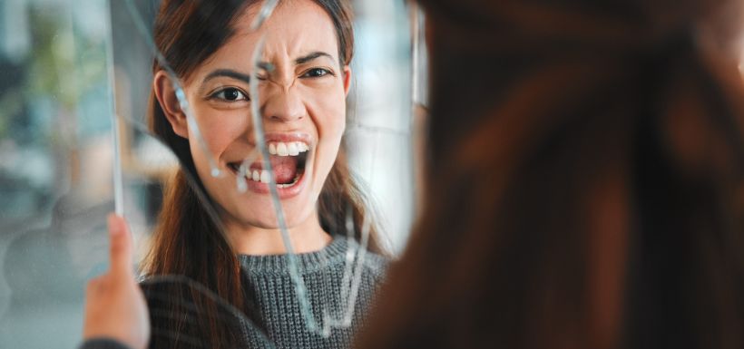 Femme qui casse son miroir, cela représente les journées mondiales de la schizophrénie