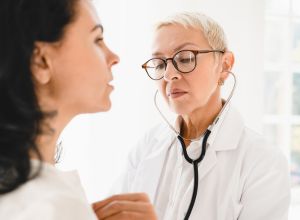 Docteur qui examine la bronchite asthmatiforme d'une femme.