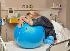 femme sur un ballon lors de son accouchement