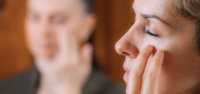 femme se tenant le dessous de l'oeil eft